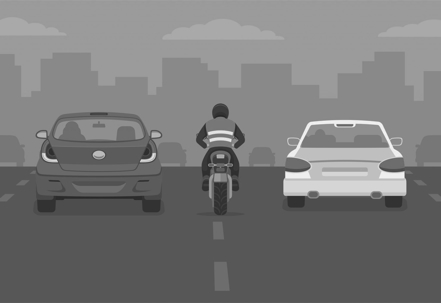 motorcycle lane splitting between two card on the freeway